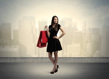 Alışveriş torbalarıyla duran şehir kadını.