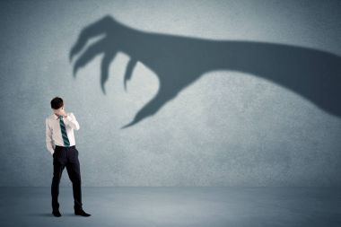 İş kişi büyük canavar pençe gölge kavramı korkuyor