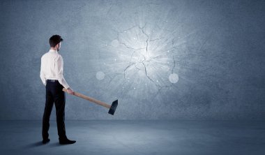 İşadamı çekiçle duvara çarpıyor.