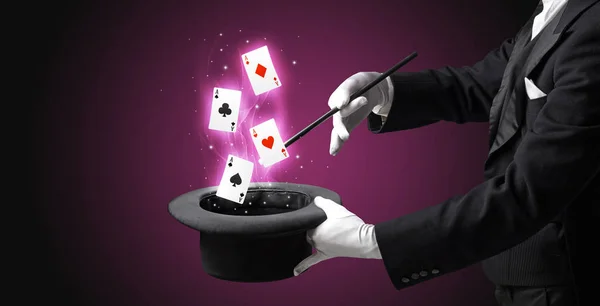 Trollkarl att göra trick med trollstav och spelkort — Stockfoto