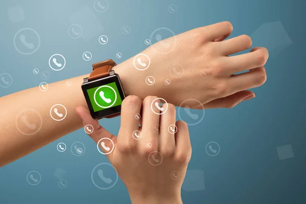 Ruka s ikonu smartwatch a volání a okolí — Stock fotografie