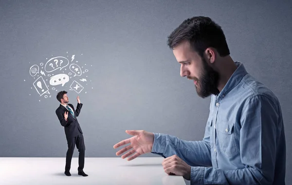 Young businessman fighting with miniature businessman — Stock Photo, Image