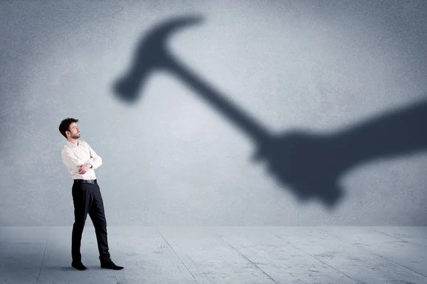 Persona de negocios miedo de una mano sombra sosteniendo el concepto de martillo — Foto de Stock