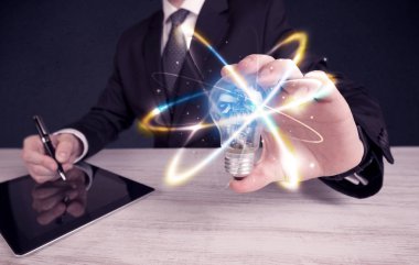 renkli bir ampul tutan işadamı