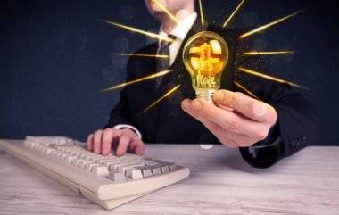 bir elektrik ampulü tutan iş kişi