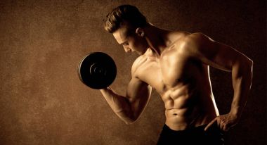 Kas formundaki vücut geliştirici sporcu ağırlık kaldırıyor 