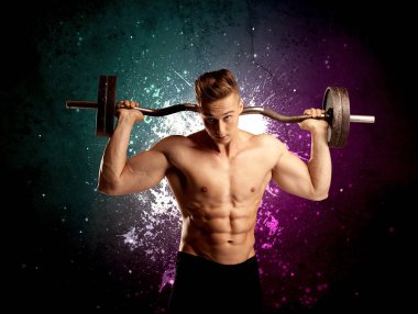 Çekici kaslı adam ağırlık kaldırıyor.
