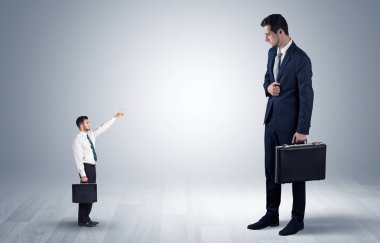 Dev bir işadamı için işaret eden küçük iş adamı