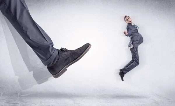 Sapato preto chutando homem pequeno — Fotografia de Stock