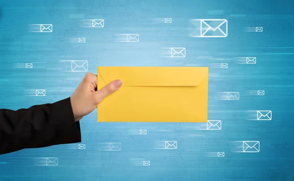 Hand holding envelope with message symbols around — Stock Photo, Image