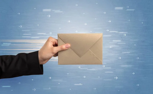 Hand holding envelope with arrows around — Stock Photo, Image