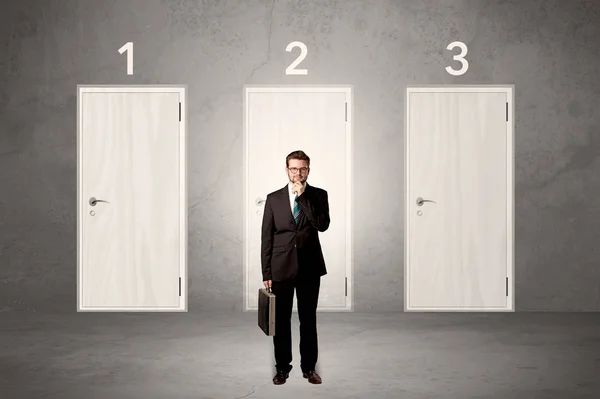 Businessman thinking in front of three doors — Stock Photo, Image