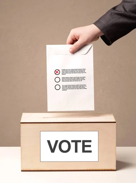 Fechar a mão masculina colocando voto em uma urna — Fotografia de Stock