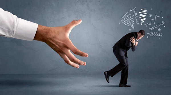 Stressful businessman running from a big hand — Stock Photo, Image