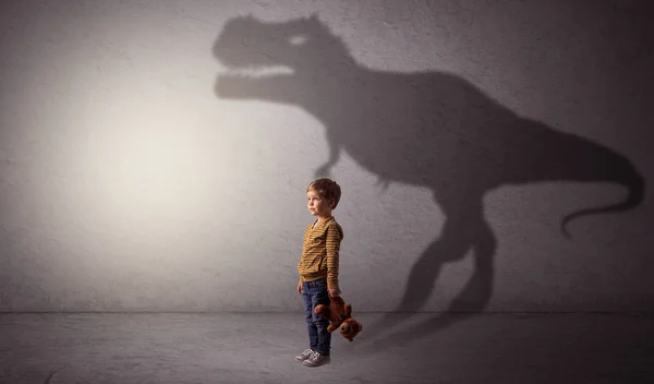 Sombra de dinossauro atrás do menino bonito — Fotografia de Stock