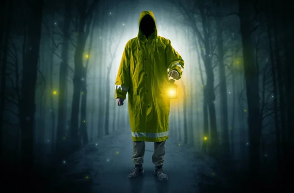 Mysterious man coming from a path in the forest with glowing lan — Stock Photo, Image