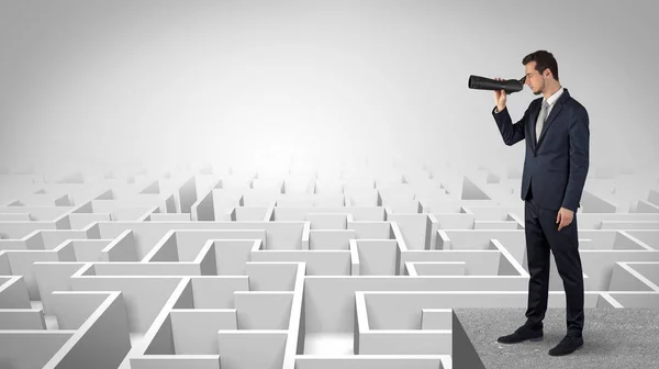 Homem em pé em cima de um labirinto com binóculos — Fotografia de Stock