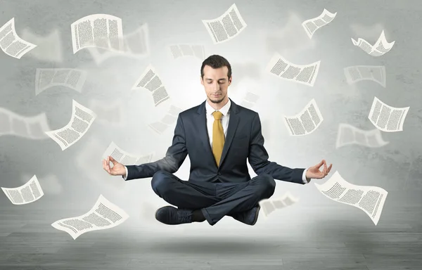 Businessman meditating with flying paper concept — Stock Photo, Image