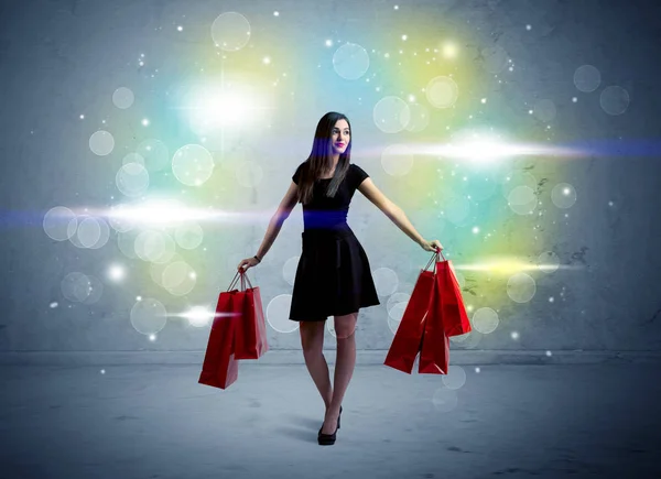 Dame du centre commercial avec des sacs à provisions et de la lumière pailletée — Photo