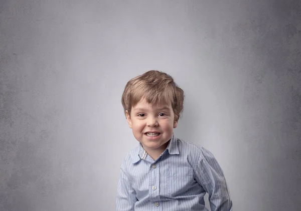 Entzückender kleiner Junge vor einer leeren Wand — Stockfoto