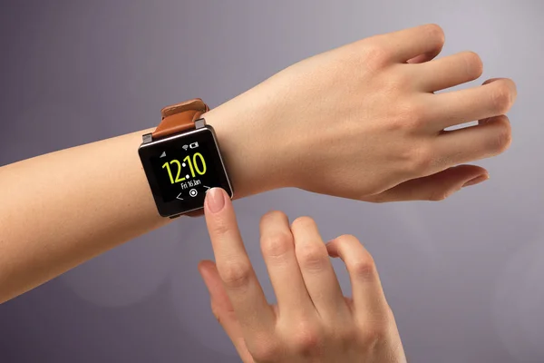 Female hand wearing and pressing smartwatch — Stock Photo, Image