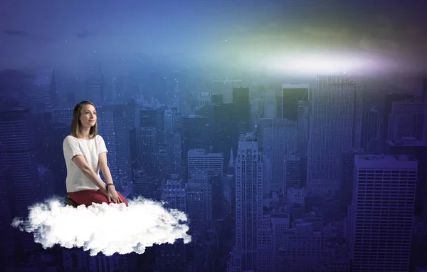 Mujer sentada en la nube sobre la ciudad — Foto de Stock