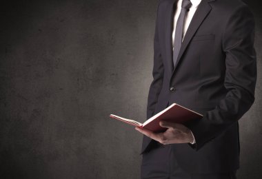 Elinde kitap tutan bir işadamı.