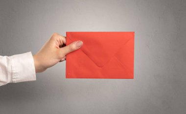 Zarf boş duvar arka plan ile tutan el