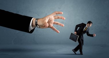 İş adamı büyük bir el kavramından kaçıyor.
