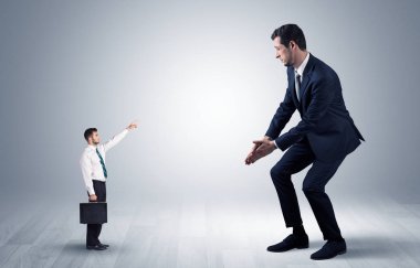 Dev bir işadamı için işaret eden küçük iş adamı