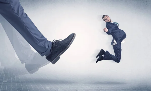 Businessman foot kicking small businessman — Stock Photo, Image