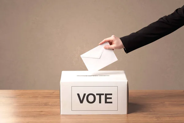Крупный план мужской руки, помещающей голоса в урну для голосования — стоковое фото
