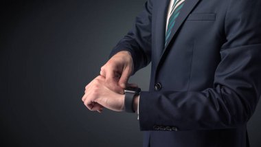 Smartwatch giyen takım elbiseli adam.