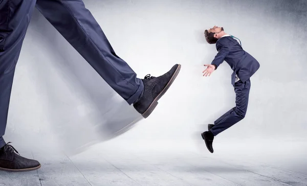 Grande perna chutando pequeno homem — Fotografia de Stock