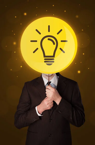 Businessman holding lightbulb sign — Stock Photo, Image