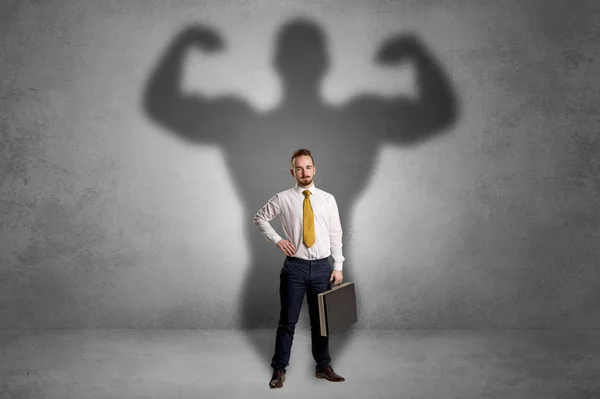 Geschäftsmann mit muskulösem Schatten hinter dem Rücken — Stockfoto