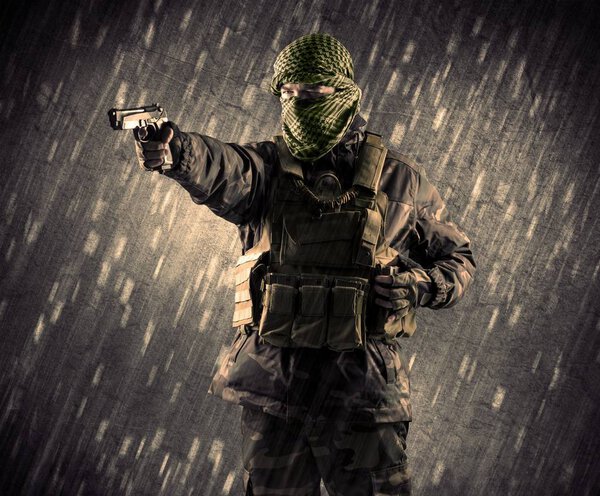 Вооруженный террорист в маске на дождевом фоне
