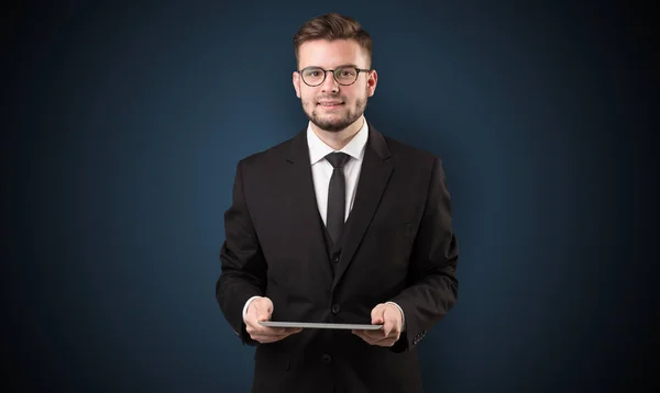 Empresario sosteniendo tableta con fondo oscuro — Foto de Stock