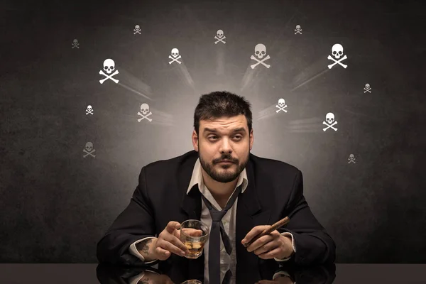 Pijany mężczyzna siedzący przy stole z koncepcją czaszki — Zdjęcie stockowe