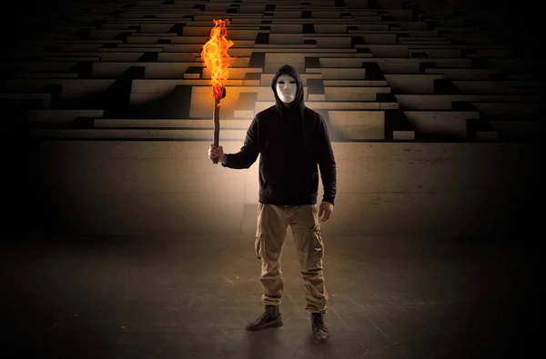 Muž přichází s hořící flambeau od konceptu bludiště — Stock fotografie