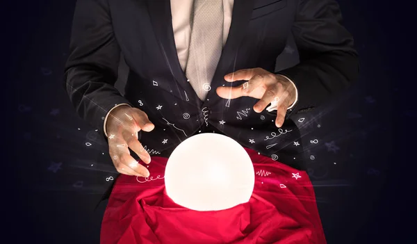 Бизнесмен, ищущий вдохновение в волшебном шаре с каракулями — стоковое фото
