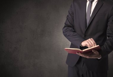 Elinde kitap tutan bir işadamı.