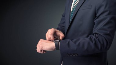 Smartwatch giyen takım elbiseli adam.