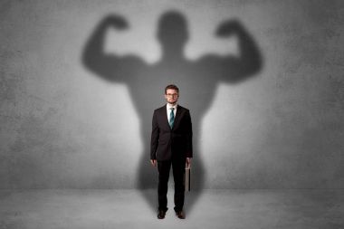 Businessman with muscular shade behind his back clipart