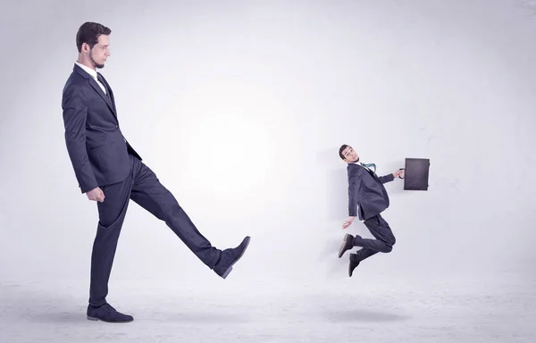 Gran hombre pateando poco a sí mismo fuera — Foto de Stock