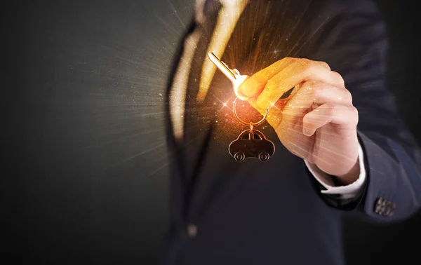 Man in suit hand over keys — Stock Photo, Image