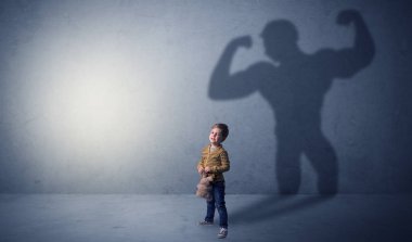 Waggish küçük çocuk arkasında muscleman gölge