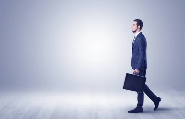 Empresario caminando frente a una pared vacía — Foto de Stock