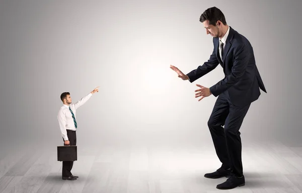 Pequeno empresário apontando para um empresário gigante — Fotografia de Stock