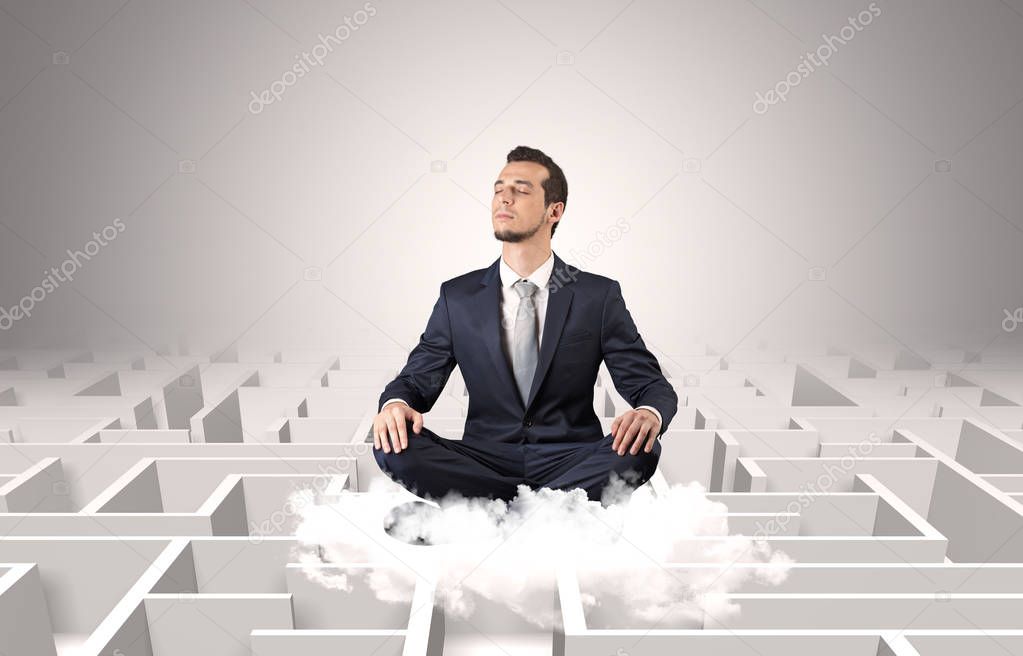 Businessman meditates on a cloud with maze concept